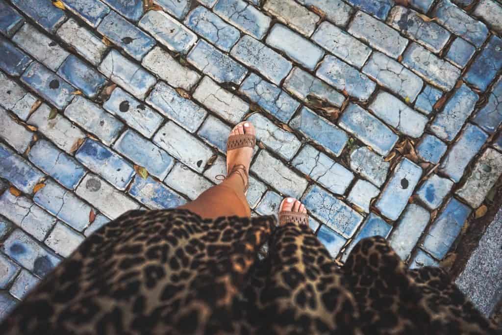 womens tanned legs walking along cobble stoned street in old san juan puerto rico