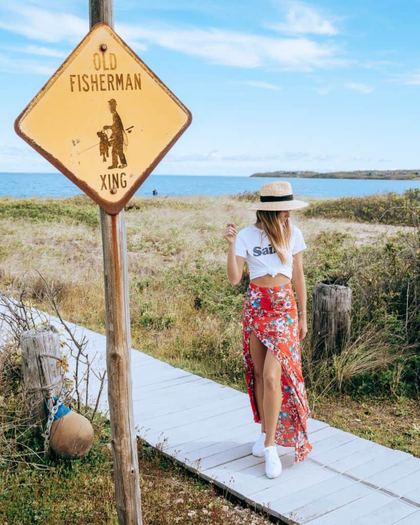 woman next to old fisherman crossing sign