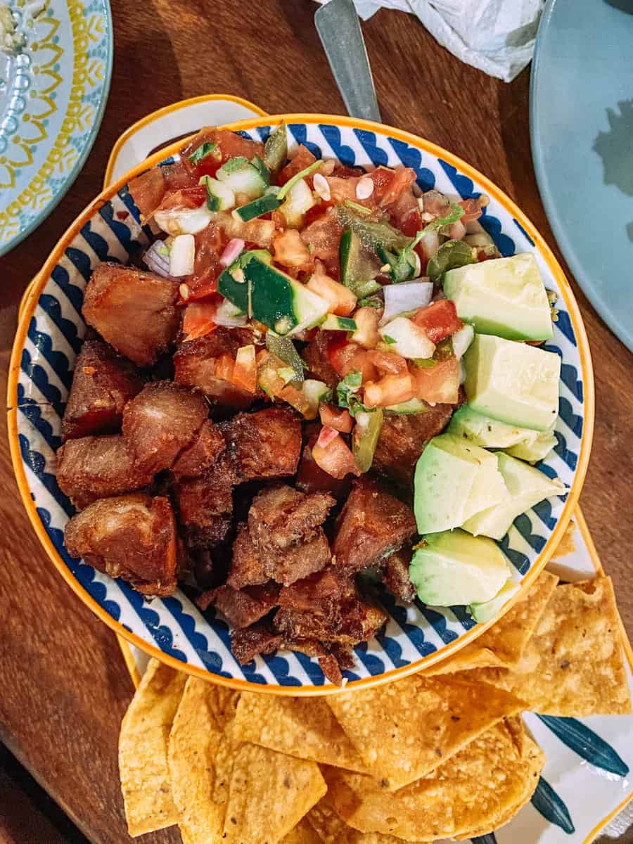 bowl of chifrio. Friend Pork cubes with salsa and avocado