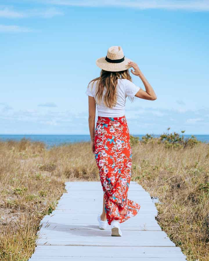 woman wearing red skirt walking down path to beach montauk ny