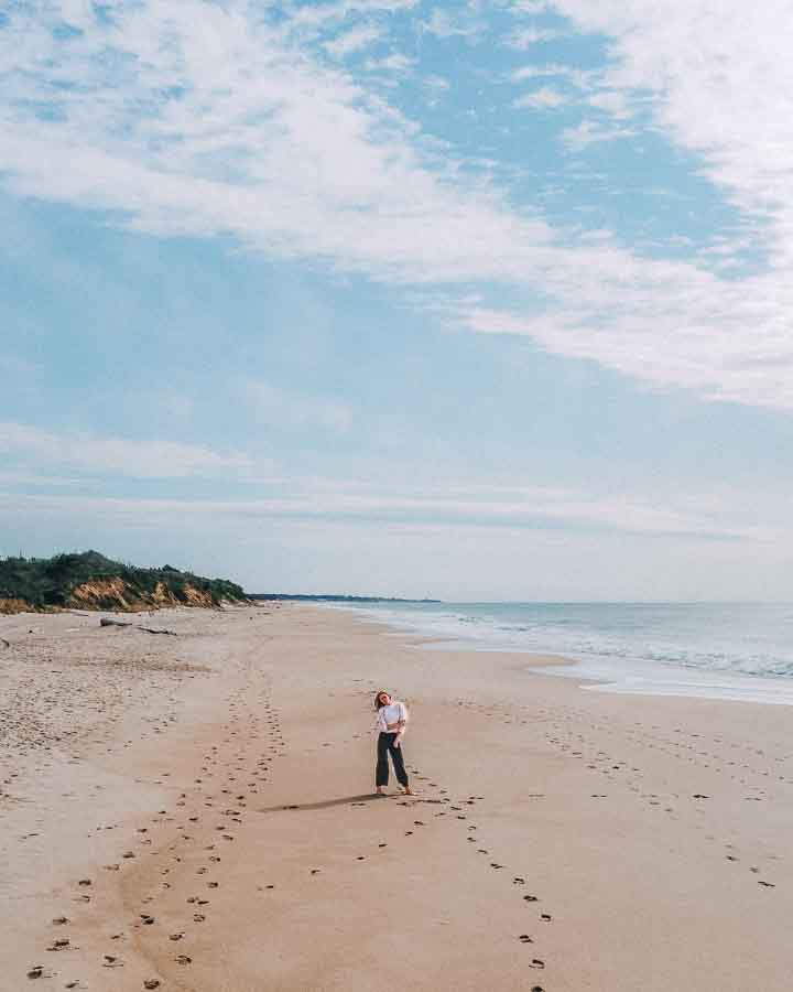 woman standing on empty beach montauk ny
